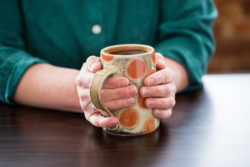 holding a hot cup of tea in a handmade mug